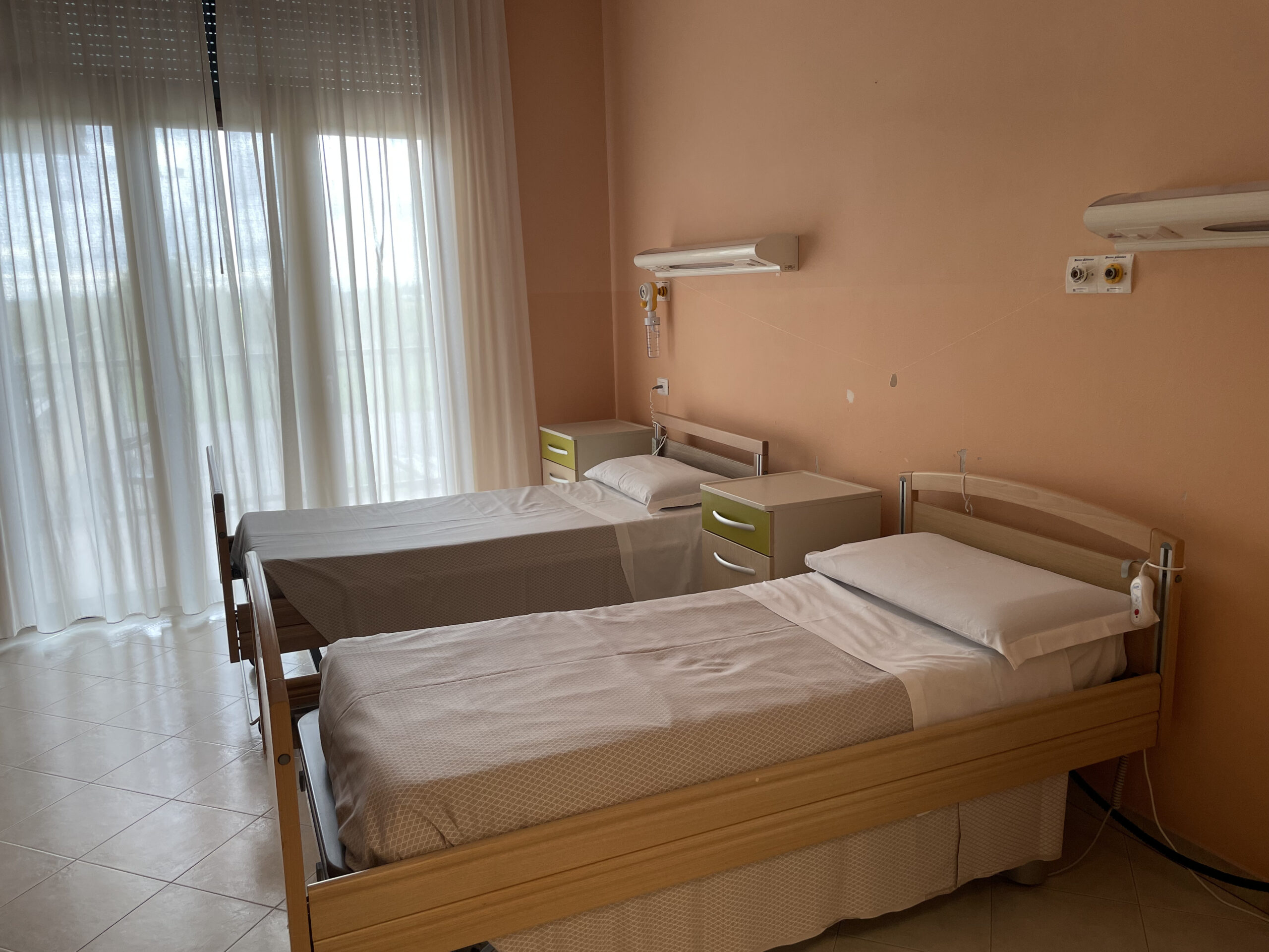 Camera luminosa con due letti singoli, sponde di sicurezza e grandi finestre